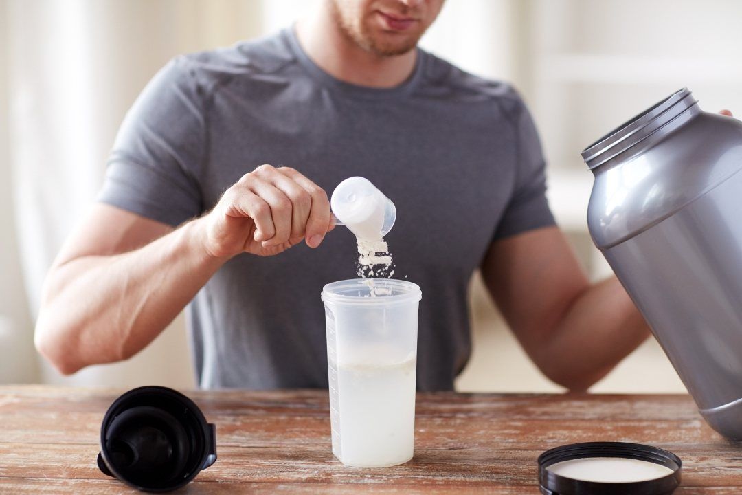 athlete pouring plant based BCAA into shaker